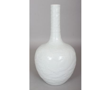 A GOOD QUALITY CHINESE WHITE GLAZED MONOCHROME PORCELAIN BOTTLE VASE, moulded beneath the glaze with dragons and cloud scroll