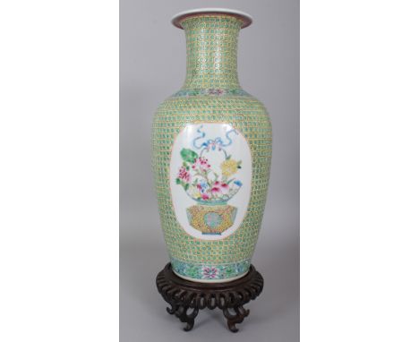 A LARGE GOOD QUALITY CHINESE FAMILLE ROSE PORCELAIN VASE, together with a wood stand, the sides decorated with two oval panel