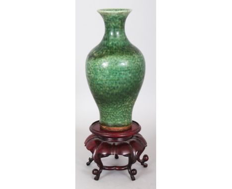 A GOOD 18TH CENTURY CHINESE GREEN GLAZED BALUSTER PORCELAIN VASE, together with a wood stand, the sides of the vase applied w