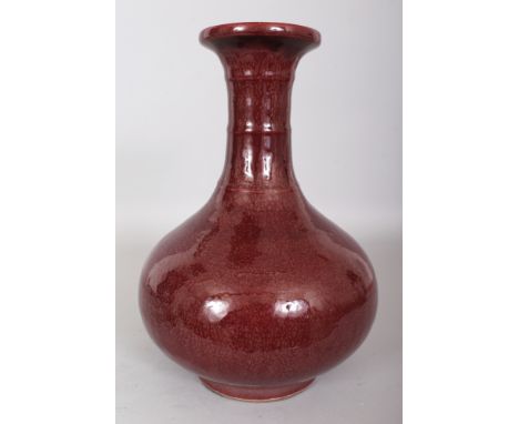 A LARGE CHINESE FLAMBE GLAZED PORCELAIN BOTTLE VASE, the sides applied with a streaked red glaze, 12.75in high.