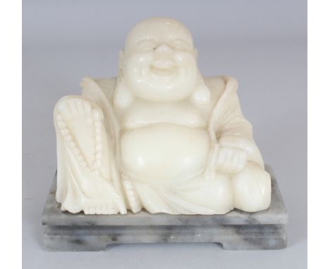AN EARLY/MID 20TH CENTURY WHITE SOAPSTONE MODEL OF BUDAI, mounted on a grey rectangular soapstone stand, 2.75in high overall,