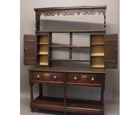 the top with fret carving and three shelves flanked by cupboards, the base with two drawers on turned supports above a pot sh