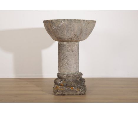 A LARGE COMPOSITE STONE FONT the basin supported on a columnar plinth, on a turned and stepped base, 99cm high x 72cm wide