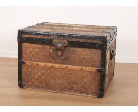 A VINTAGE TRAVEL TRUNK decorated in Louis Vuitton style, the hinged lid opening to an interior fitted with a shelf, 41cm high