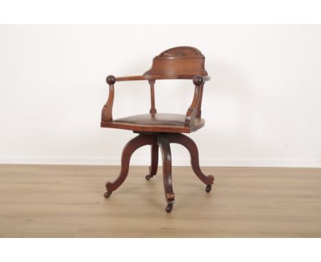 AN EDWARDIAN MAHOGANY DESK CHAIR with sunburst carved cresting and stuffed leather serpentine seat on a rotating base, the fo