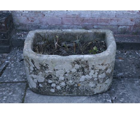 A SMALL STONE TROUGH of D-shape section, 32cm high x 67cm wide x 49cm deep