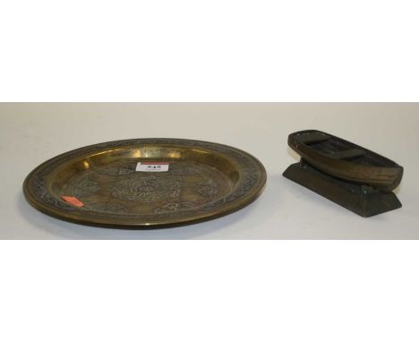 An eastern copper and brass dish, decorated with the Star of David, dia.22cm; together with a brass model of a boat (2)