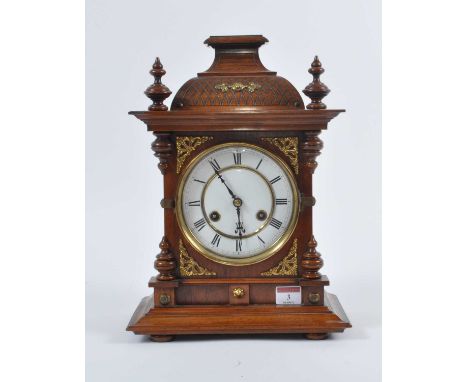 An early 20th century walnut cased eight-day mantel clock, the enamel dial showing Roman numerals, h.36cmBezel has been re-so