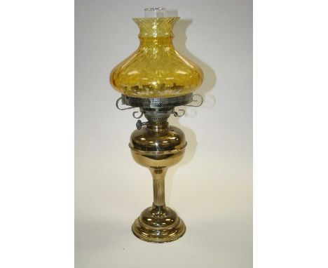 A late 19th century brass oil lamp, having amber tinted glass shade, h.58cm