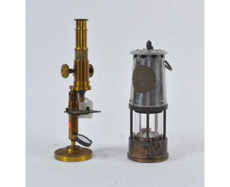 An early 20th century brass monocular microscope, h.29cm; together with an M&amp;Q type 6 miner's lamp, h.24cm (2)