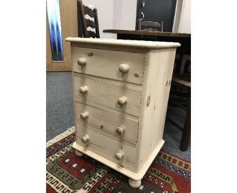 A light pine four drawer bedside chest