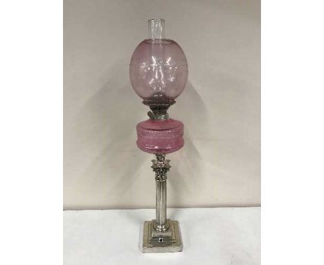 A Victorian Corinthian column oil lamp with pink glass shade 