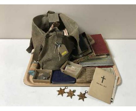 A tray of containing eight WWII medals with ribbons, cap badges, army prayer books, photographs etc 
