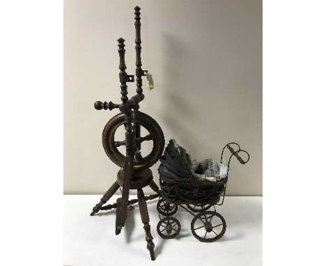 A vintage spinning wheel and Victorian style miniature pram with doll 