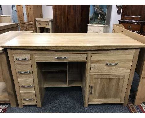 A contemporary light oak pedestal desk fitted with drawers