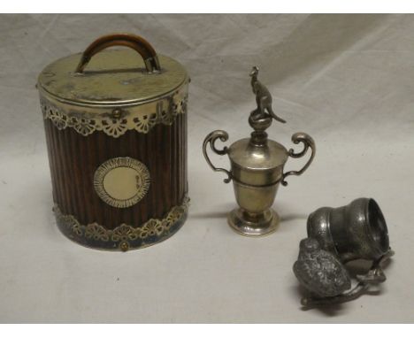 A small silver trophy-style cup with kangaroo finial, oak and electroplated cylindrical jar and cover and a base metal napkin