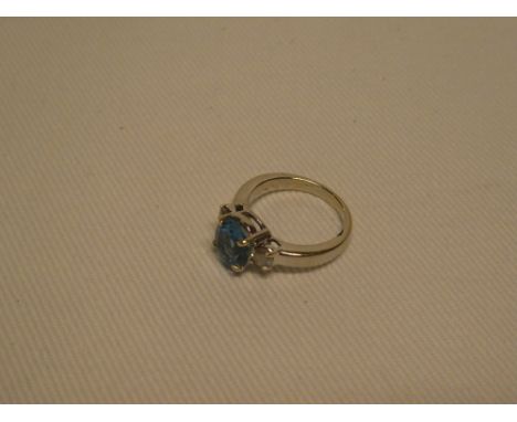 An 18ct white gold dress ring set tanzanite flanked by two diamonds