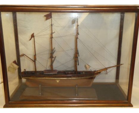 An old wooden scale built model of three-masted schooner within scenic glazed mahogany display case 26" long x 20½" high