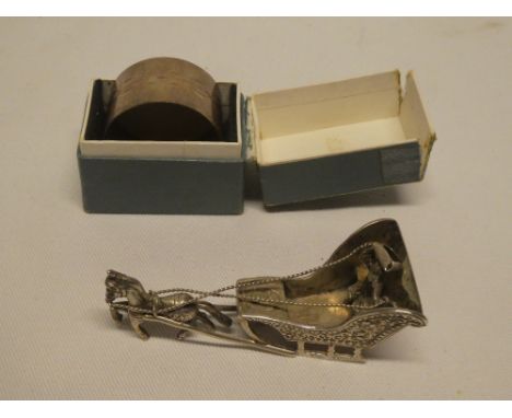 A Continental silver figure of a horse and sleigh 3½" long and a boxed silver circular napkin ring (2)