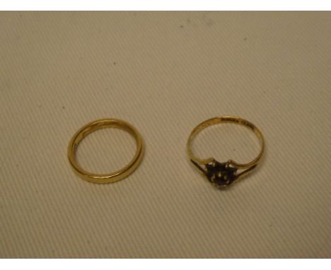 A 9ct gold dress ring with floral mounts set garnets and a 9ct gold wedding band (2)