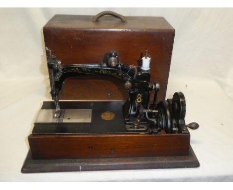 A vintage sewing machine by Wheeler &amp; Wilson in polished stained wood case