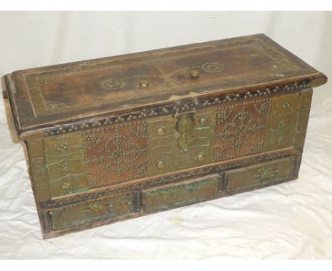 An old Indian wooden rectangular trunk decorated with brass strips and brass headed nails with three base drawers and hinged 