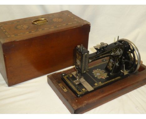 A vintage sewing machine "The Wanzer" in inlaid walnut case