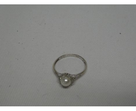 A 9ct white gold dress ring set pearls surrounded by diamond chips