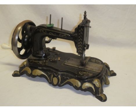 An old manual sewing machine with painted frame on scroll base