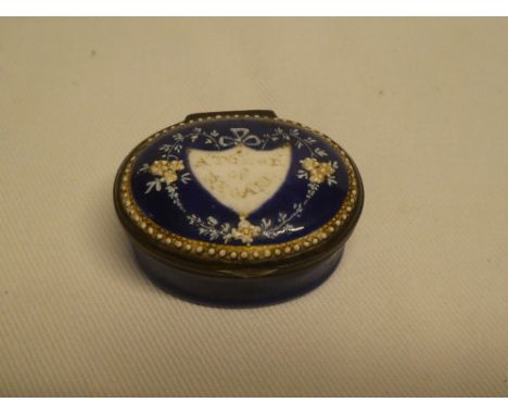 A late 18th/early 19th century enamelled oval patch box, the hinged decorated lid marked "A Token Of Regard" (slight damage)