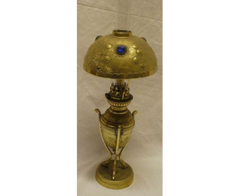 An unusual small brass oil lamp with glass chimney and brass domed cover