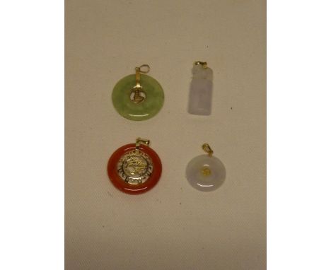 Four various Chinese 14ct gold mounted jade pendants with pierced decoration