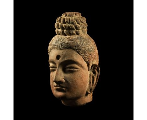 3rd-5th century AD.&nbsp;A terracotta head of Buddha with long ears, ridged eyebrows, serene facial expression; ribbed top-kn