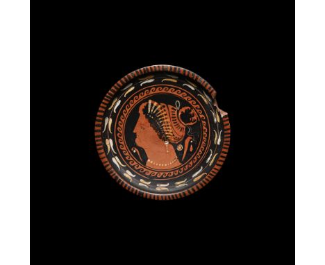 5th-4th century BC. An Apulian red-figure phiale, with ochre and white, decorated on the chipped edge by a series of parallel