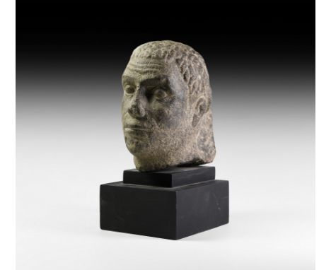 Ptolemaic Period, 332-30 BC. A carved black granite head of a male with realistic features, the oblong face showing several s