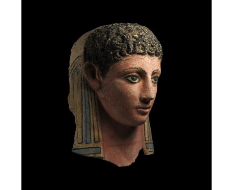 Roman Period, mid 2nd century AD. A polychrome plaster mask of a curly-headed young male, with additional curls painted to th