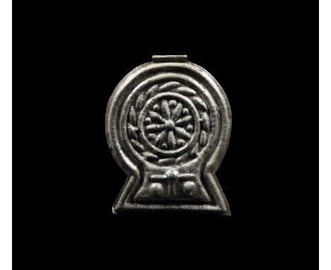 11th-9th century BC. A large silver repoussé pendant with integral tubular suspension loop; the pendant shape is broadly a di