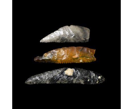 Neolithic, 6th-3rd millennium BC. A group of three finely knapped flint knives, each with a straight edge and a curved back; 