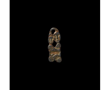 8th-9th century AD. A bifacial pendant formed as an embracing couple in an erotic position, facing, with detailing to the fac