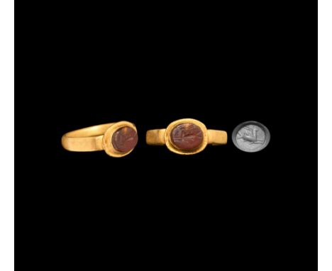 3rd century AD. A carnelian gemstone with intaglio advancing capricorn; set into a later gold finger ring with facetted hoop,