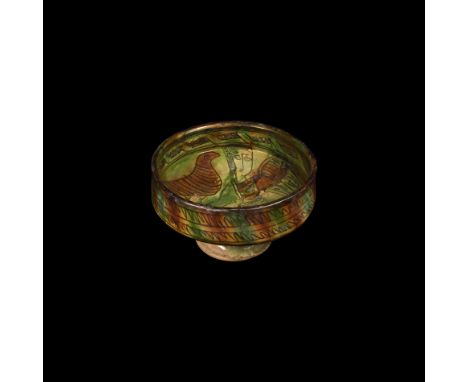 13th-14th century AD. A ceramic bowl with carinated body and flared foot, cream glaze with splashed amber and green, circumfe