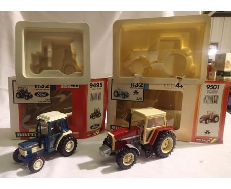 Two Britains tractors to include 9495- Ford 2120 and 9501-MF 3680 both are as new but have fading/yellowing on one side of mo