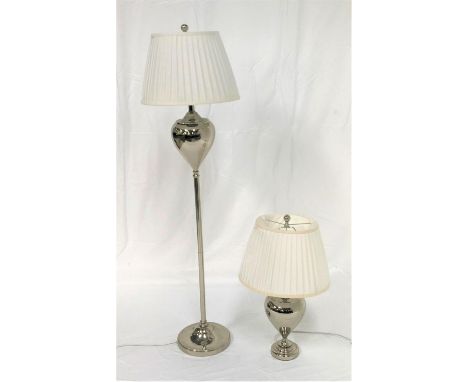 POLISHED STEEL STANDARD LAMPraised on a circular base with a shaped column and a white pleated shade, 147cm high, together wi