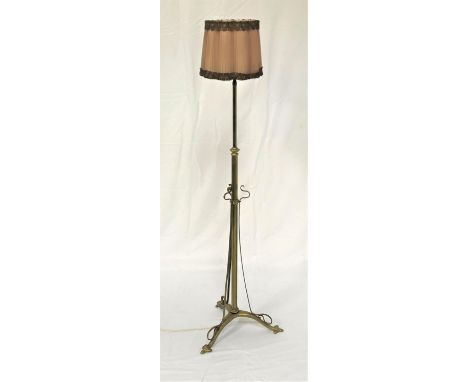 BRASS TELESCOPIC STANDARD LAMPof tubular form raised on a tripod base, with a pleated shade, 194cm extended 