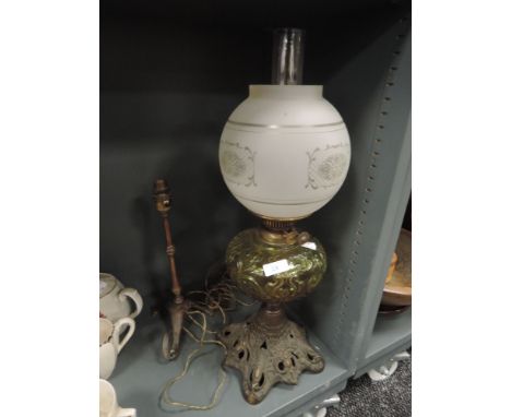 A Victorian oil burning lamp having cast base, yellow pressed glass well and heavy etched shade