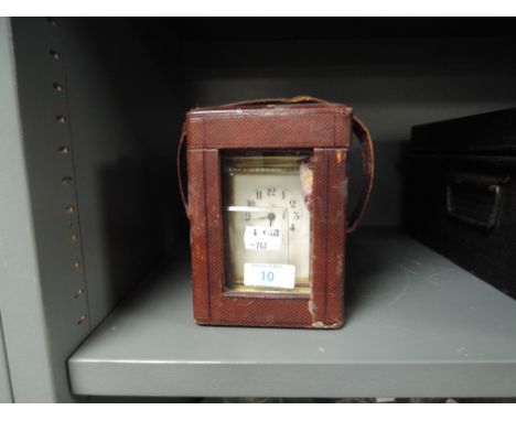 A brass cased carriage clock possibly late 19th century having leather case and enamel face dial