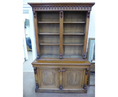 An Arts and Crafts Oak Book Case, lower case having one shelf and double doors, the top having double glazed doors with three