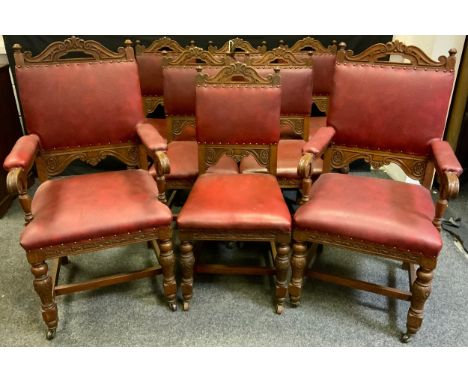 A set of eight Gothic revival oak dining chairs (six chairs and two carvers), red leather backs and seats, carved throughout,
