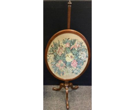 A late Victorian mahogany pole screen, the glazed oval screen with an embroidered floral panel, tripod base, c.1890. 