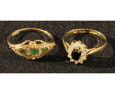 An emerald and diamond nine stone cluster ring, 9ct gold shank, 2g gross;  dark blue synthetic sapphire and Cz oval cluster r